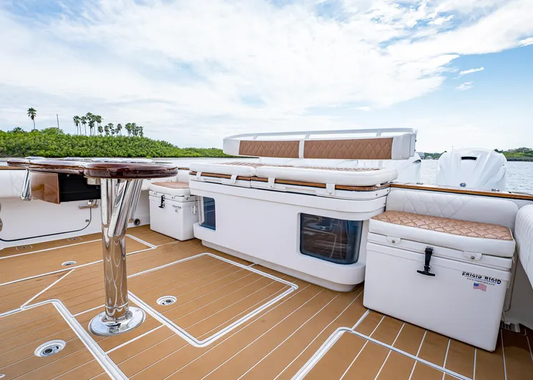  Yacht Photos Pics 2020 HCB Suenos boat deck with seating, table, and storage, under a partly cloudy sky.