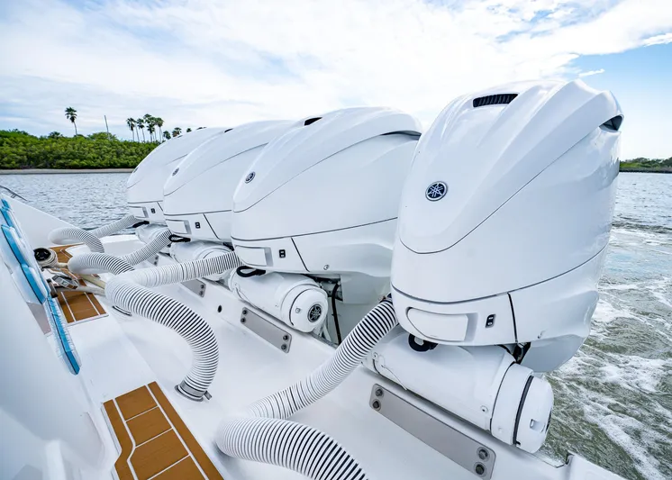  Yacht Photos Pics Four powerful outboard engines on a 2020 HCB Suenos boat, cruising on a scenic waterway.
