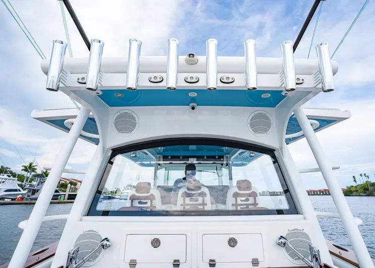  Yacht Photos Pics 2020 HCB Suenos boat cockpit with rod holders and seating, under a clear blue sky.
