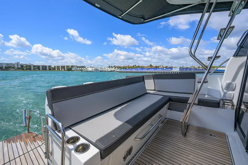 Don't Wake Me Yacht Photos Pics 2022 Jeanneau NC Weekender 1095 Fly, spacious deck with seating, overlooking marina and blue sky.