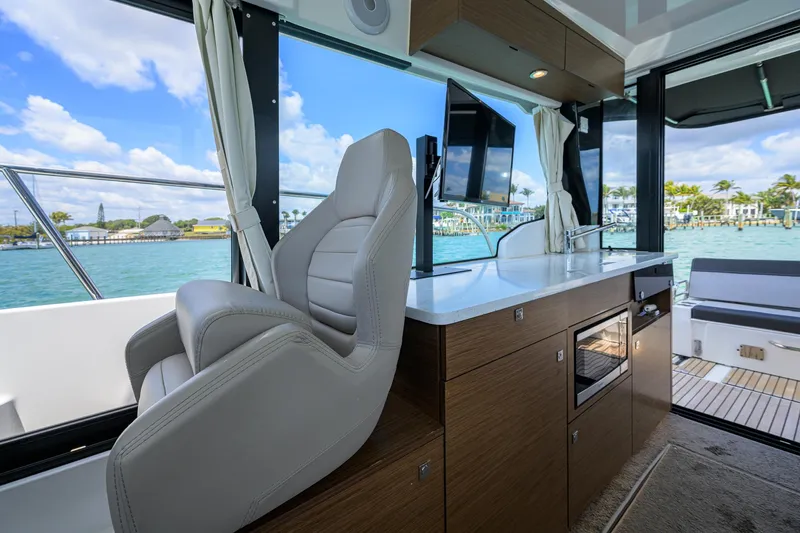Don't Wake Me Yacht Photos Pics Interior of 2022 Jeanneau NC Weekender 1095 Fly, featuring helm seat and modern amenities.