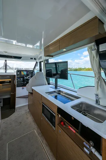 Don't Wake Me Yacht Photos Pics Interior of 2022 Jeanneau NC Weekender 1095 Fly, featuring modern kitchen and helm.