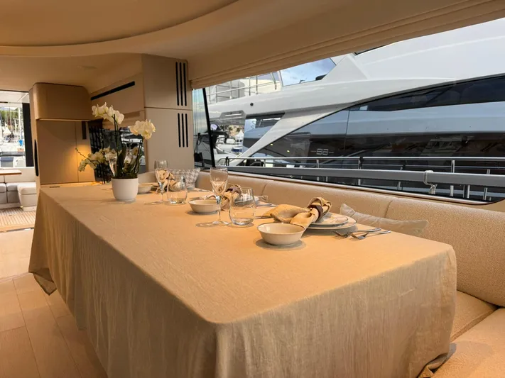  Yacht Photos Pics Luxurious dining area inside 2024 Azimut Fly 68 yacht, elegantly set table with flowers.