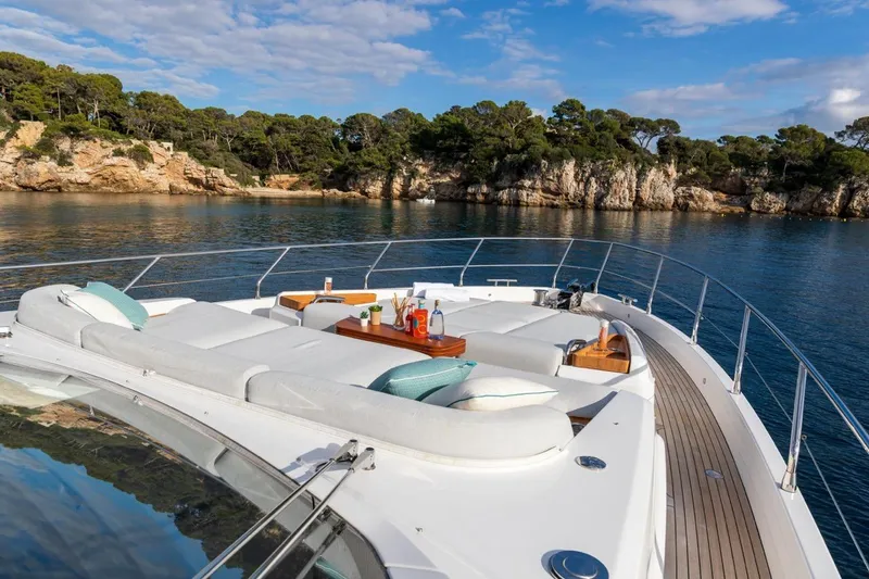  Yacht Photos Pics Luxurious 2024 Azimut Fly 68 yacht deck with sun loungers, scenic coastal view.