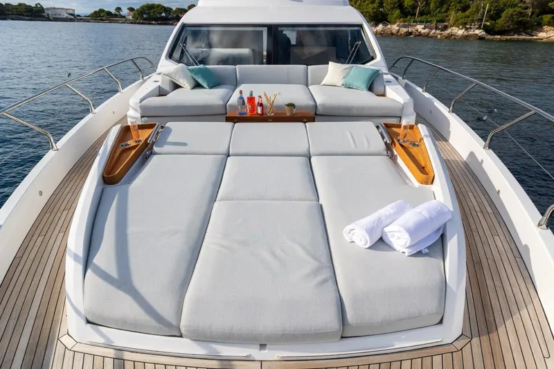  Yacht Photos Pics Luxurious 2024 Azimut Fly 68 yacht deck with sunbeds and towels, overlooking serene waters.