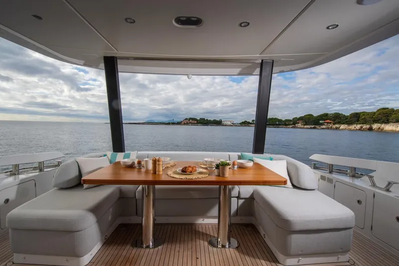  Yacht Photos Pics Luxurious 2024 Azimut Fly 68 yacht deck with elegant dining setup and scenic ocean view.