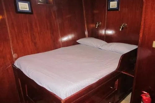  Yacht Photos Pics Cozy wooden cabin interior with a neatly made bed, 1962 Custom Southern model.