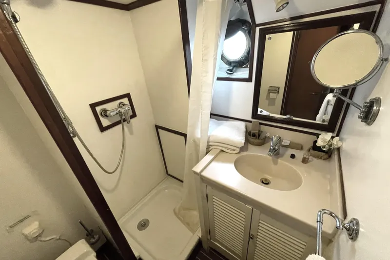  Yacht Photos Pics Compact 1962 Custom Southern bathroom with shower, sink, mirror, and nautical porthole window.