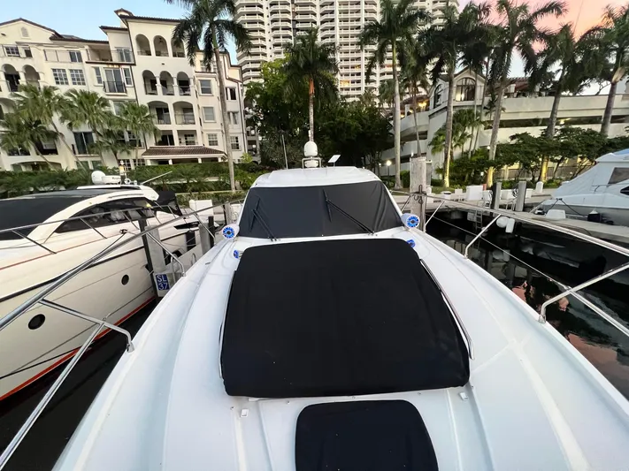  Yacht Photos Pics Beneteau Monte Carlo 47 yacht docked, 2010 model, surrounded by palm trees and luxury buildings.
