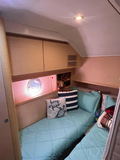  Yacht Photos Pics Cozy cabin interior of 2010 Beneteau Monte Carlo 47 with twin beds and decorative pillows.