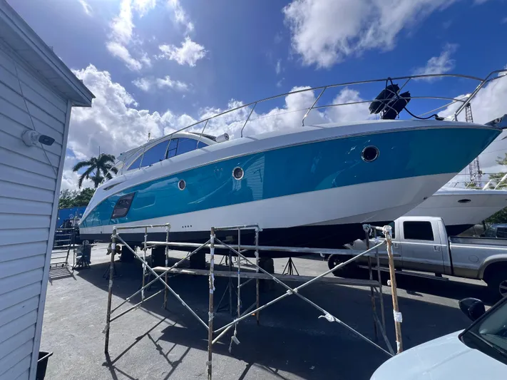  Yacht Photos Pics Beneteau Monte Carlo 47 yacht, 2010 model, elevated on scaffolding under a bright blue sky.