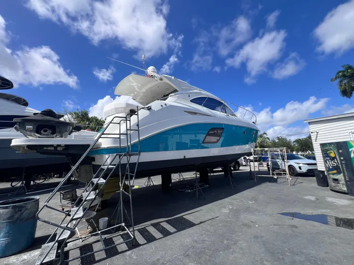  Yacht Photos Pics 2010 Beneteau Monte Carlo 47 yacht on dry dock under a clear blue sky.