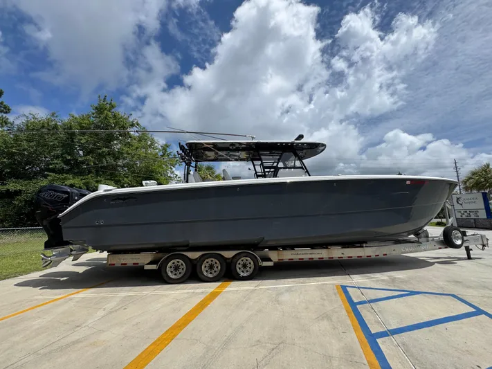  Yacht Photos Pics 2020 Invincible 40 Catamaran on trailer, parked outdoors under cloudy sky.