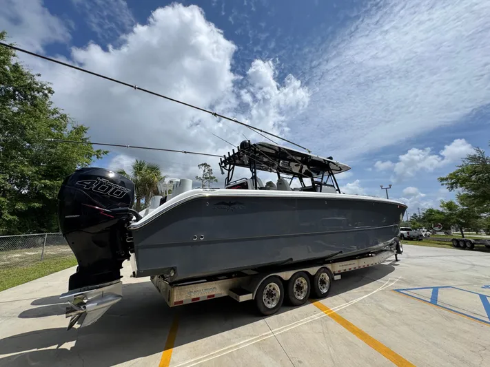  Yacht Photos Pics 2020 Invincible 40 Catamaran on trailer, parked outdoors under a partly cloudy sky.