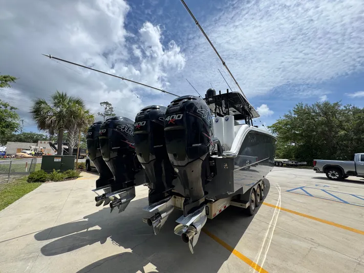  Yacht Photos Pics 2020 Invincible 40 Catamaran with powerful outboard engines, parked outdoors under a cloudy sky.