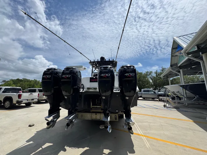  Yacht Photos Pics 2020 Invincible 40 Catamaran with four powerful outboard engines, parked outdoors under a cloudy sky.