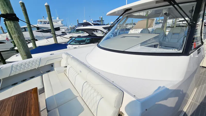  Yacht Photos Pics 2021 Regal 38 SAV luxury boat docked at marina, featuring spacious seating and sleek design.
