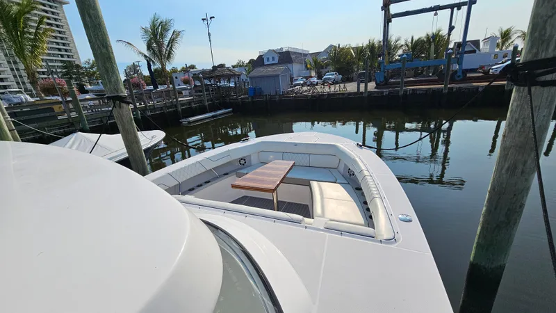  Yacht Photos Pics 2021 Regal 38 SAV boat docked, featuring spacious seating and table on deck.