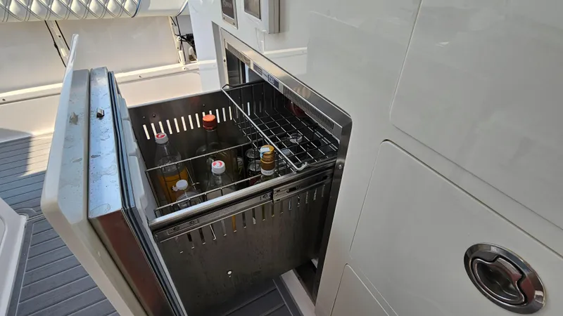  Yacht Photos Pics Open beverage cooler on 2021 Regal 38 SAV boat, showcasing interior storage.