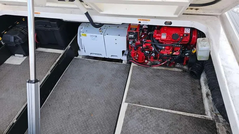  Yacht Photos Pics Engine compartment of a 2021 Regal 38 SAV boat, featuring a red engine and storage areas.