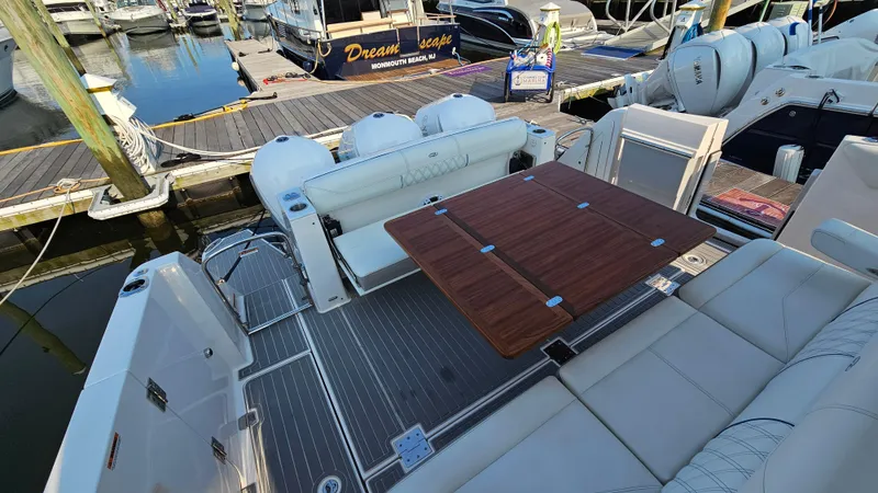  Yacht Photos Pics 2021 Regal 38 SAV boat interior with seating and wooden table at marina.