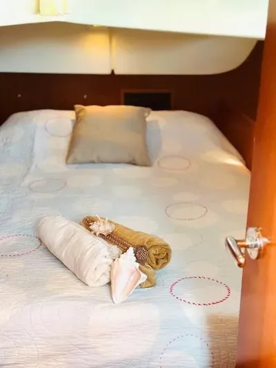 Karuna Ss Yacht Photos Pics Cozy bedroom in 2007 Beneteau 49' Cruiser with neatly arranged linens and seashell decor.