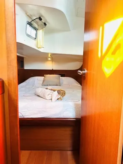 Karuna Ss Yacht Photos Pics Cozy cabin interior of a 2007 Beneteau 49' Cruiser with a neatly made bed.
