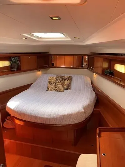 Karuna Ss Yacht Photos Pics Luxurious interior of 2007 Beneteau 49' Cruiser with cozy bed and elegant wood finish.