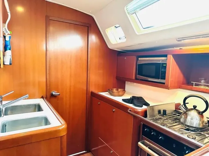 Karuna Ss Yacht Photos Pics Galley kitchen in 2007 Beneteau 49' Cruiser with wood cabinetry and modern appliances.