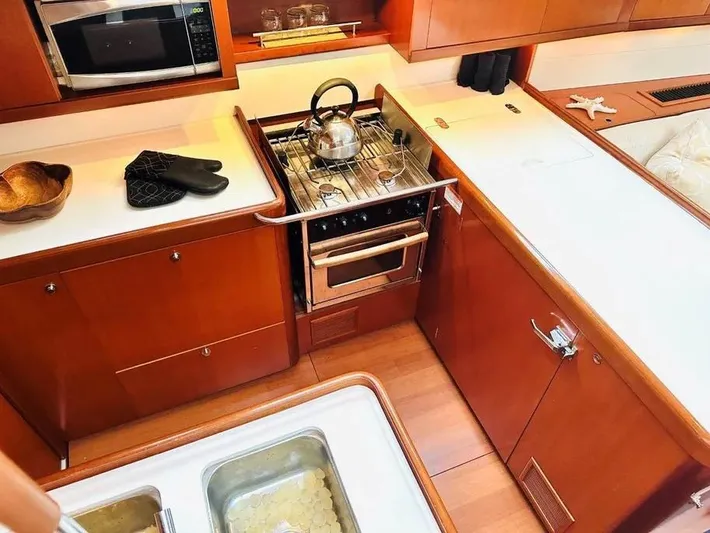 Karuna Ss Yacht Photos Pics 2007 Beneteau 49' Cruiser kitchen with stove, oven, and wooden cabinetry.