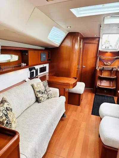 Karuna Ss Yacht Photos Pics Luxurious interior of a 2007 Beneteau 49' Cruiser with elegant wood finishes and cozy seating.