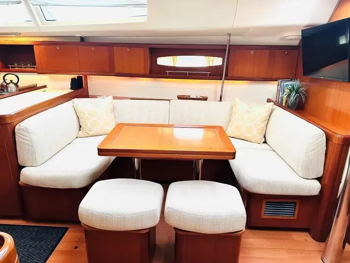 Karuna Ss Yacht Photos Pics Interior of 2007 Beneteau 49' Cruiser with cozy seating and wooden table.