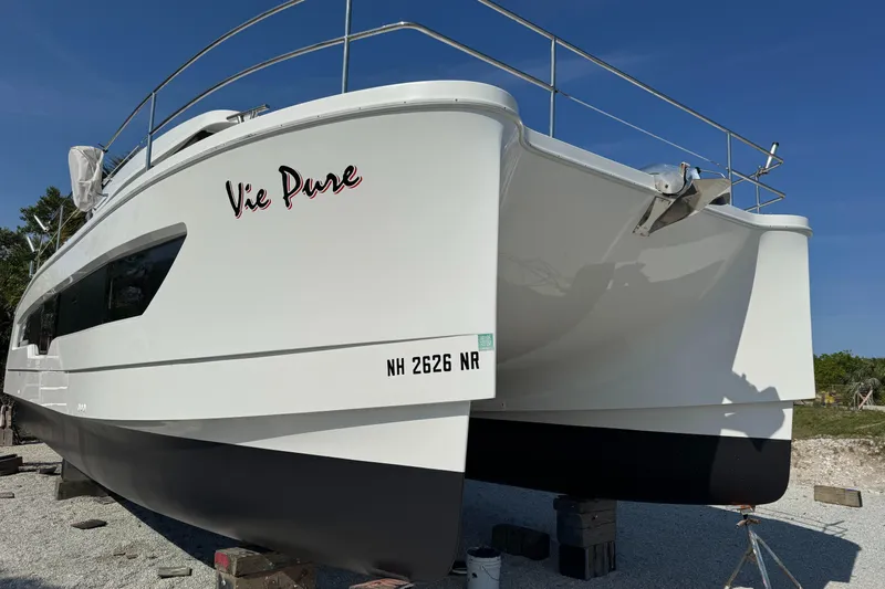 Vie Pure Yacht Photos Pics 2021 Fountaine Pajot MY4.S catamaran on land, white hull, blue sky background.