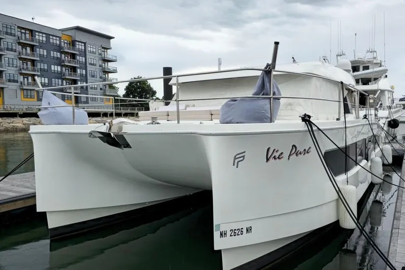 Vie Pure Yacht Photos Pics 2021 Fountaine Pajot MY4.S catamaran docked near modern waterfront apartments.