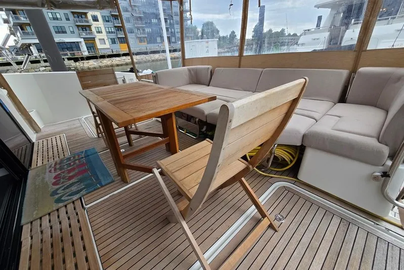 Vie Pure Yacht Photos Pics 2021 Fountaine Pajot MY4.S yacht deck with wooden furniture and cushioned seating.