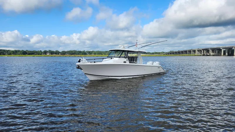Blown Dough Yacht Photos Pics 2023 Pursuit S 358 Sport boat on calm water under a blue sky.