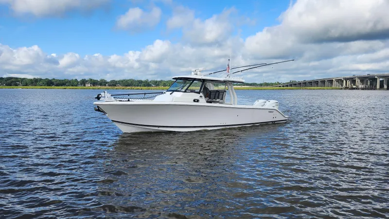 Blown Dough Yacht Photos Pics 2023 Pursuit S 358 Sport boat on calm water under a blue sky.