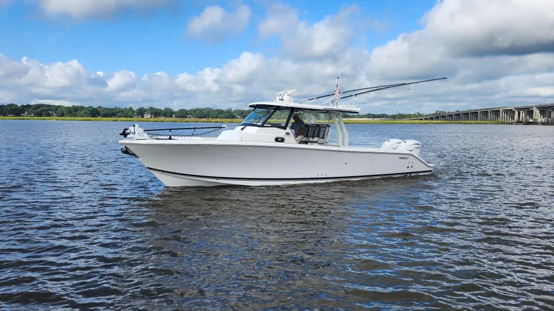 Blown Dough Yacht Photos Pics 2023 Pursuit S 358 Sport boat on calm water under a cloudy sky.