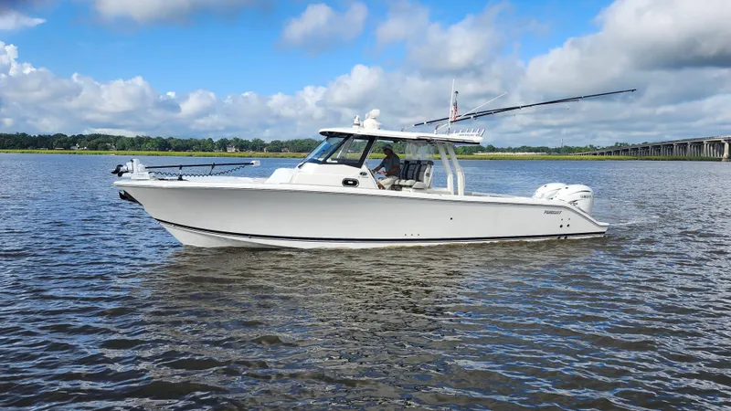 Blown Dough Yacht Photos Pics 2023 Pursuit S 358 Sport boat cruising on a calm river under a blue sky.