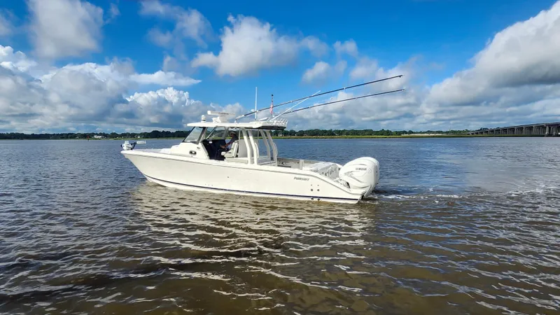 Blown Dough Yacht Photos Pics 2023 Pursuit S 358 Sport boat cruising on a calm river under a blue sky.