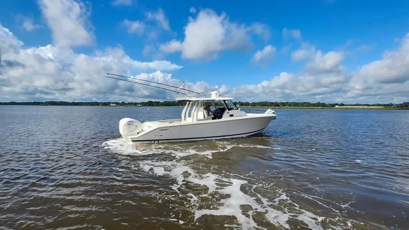 Blown Dough Yacht Photos Pics 2023 Pursuit S 358 Sport boat cruising on a sunny day with blue skies.