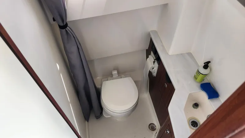 Blown Dough Yacht Photos Pics 2023 Pursuit S 358 Sport boat bathroom with toilet, sink, and storage.