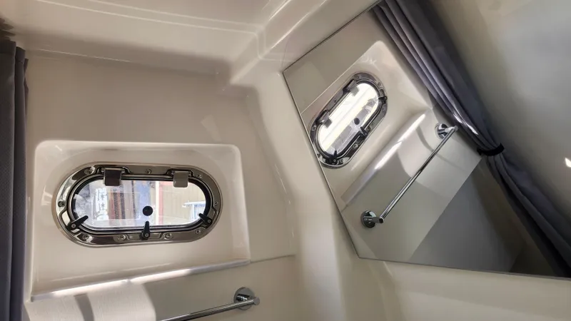 Blown Dough Yacht Photos Pics 2023 Pursuit S 358 Sport boat interior with porthole and curtain.