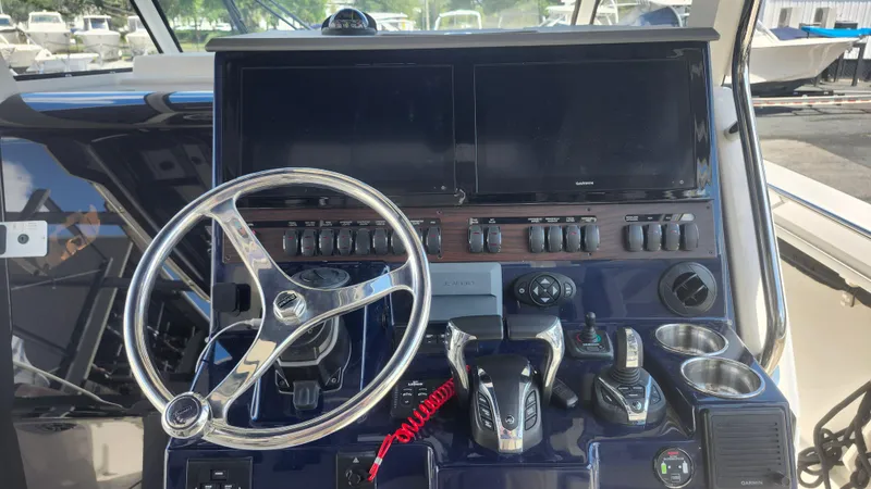 Blown Dough Yacht Photos Pics 2023 Pursuit S 358 Sport boat dashboard with steering wheel and controls.
