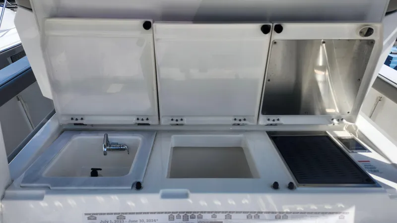 Blown Dough Yacht Photos Pics 2023 Pursuit S 358 Sport boat kitchen area with sink and storage compartments.