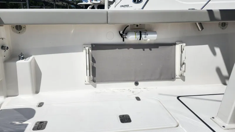 Blown Dough Yacht Photos Pics 2023 Pursuit S 358 Sport boat interior with storage compartment and fire extinguisher.