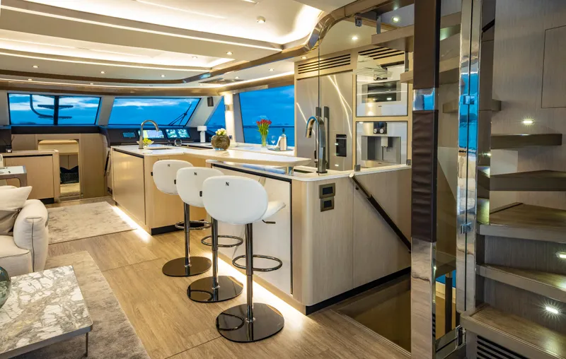 Aquila 70 Yacht Photos Pics Luxurious interior of 2026 Aquila 70 yacht with modern kitchen and seating area.