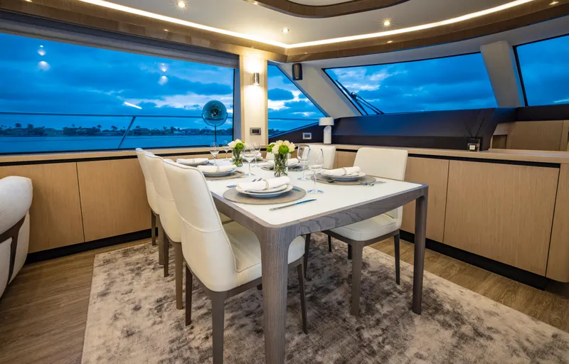 Aquila 70 Yacht Photos Pics Luxurious dining area on 2026 Aquila 70 Luxury yacht with elegant table setting and panoramic windows.