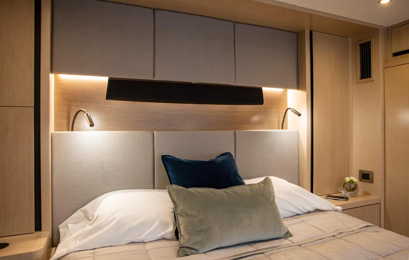 Aquila 70 Yacht Photos Pics Luxurious bedroom interior of 2026 Aquila 70 Luxury yacht with elegant lighting and plush bedding.
