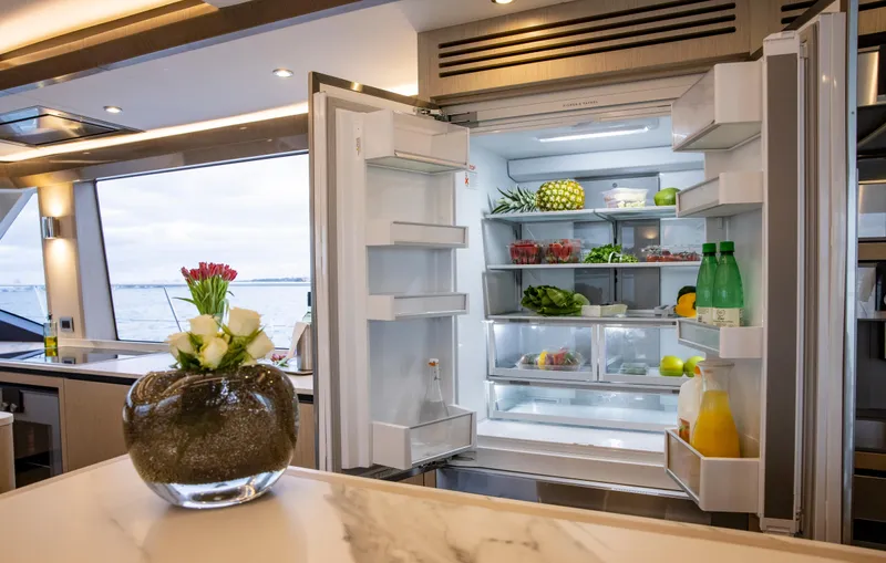 Aquila 70 Yacht Photos Pics Open refrigerator in 2026 Aquila 70 Luxury yacht kitchen with fresh produce.